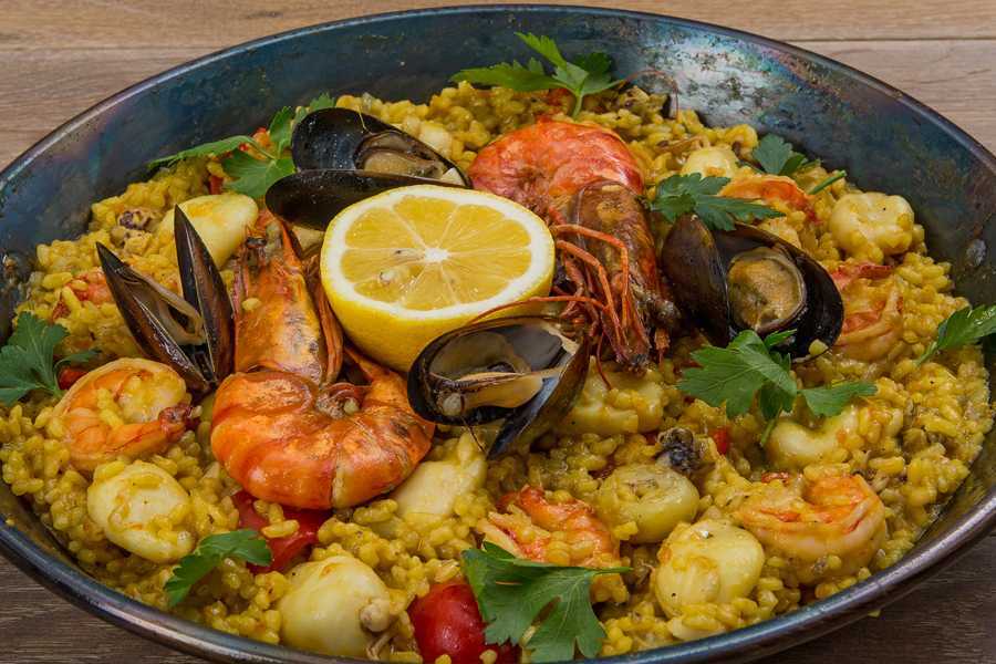 Сегодня это традиционное испанское блюдо из риса с морепродуктами, курицей и овощами можно встретить в ресторанах по всему миру Местные повара насчитывают более 300 вариаций паэльи и традиционно готовят её на открытом огне Шесть рецептов на любой вкус — в