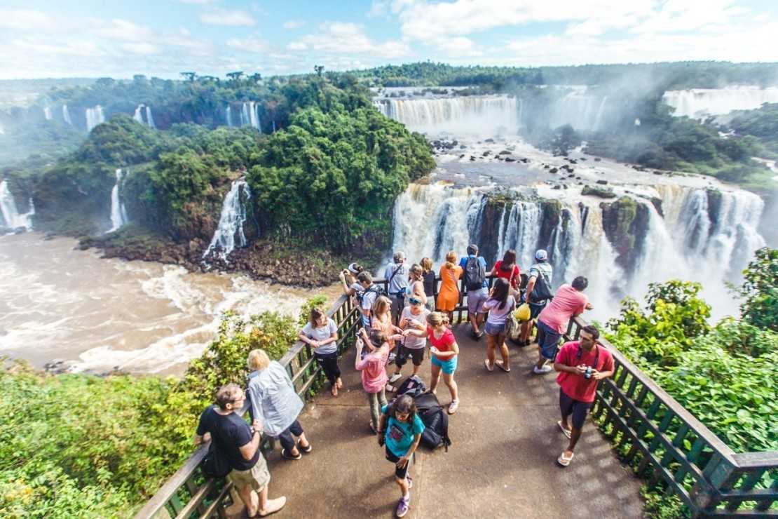 Туризм водопады. Водопады Игуасу Аргентина Бразилия. Чудеса света водопад Игуасу. Национальный парк Игуасу для туристов. Водопад Игуасу туризм.